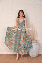 Woman wearing a floral dress with 'Meghcraft' branding against a white brick wall.